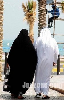  Kuwaiti man and his wife walk outside one of the biggest malls in Kuwait city in 2005.